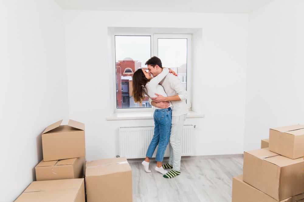 Pareja celebrando la compra de uno de los apartamentos en venta en Manizales al recibir su nuevo hogar.